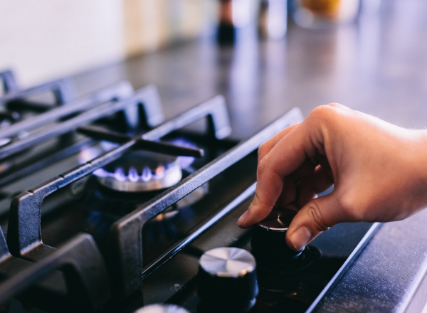 Woman turning the knob of a gas stove