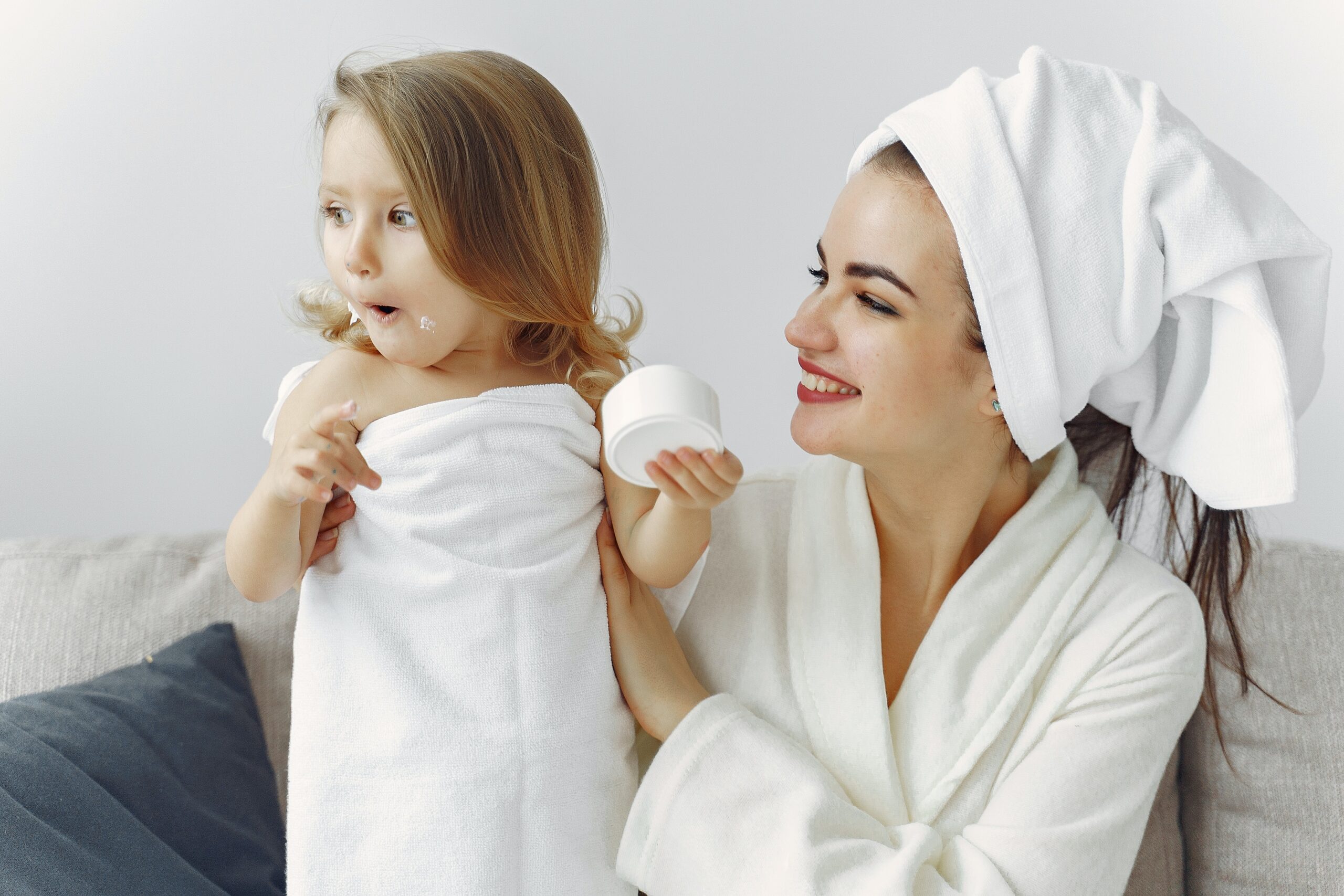 Mother and young daughter in robes and towels after a bath.